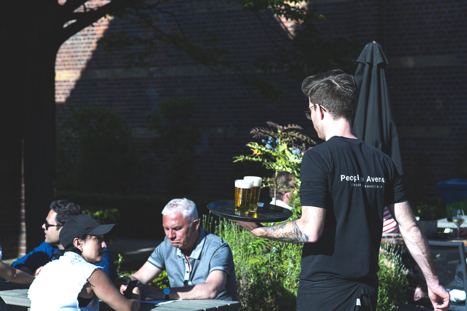 Gasten op het zonnige terras aan de Westergasfabriek